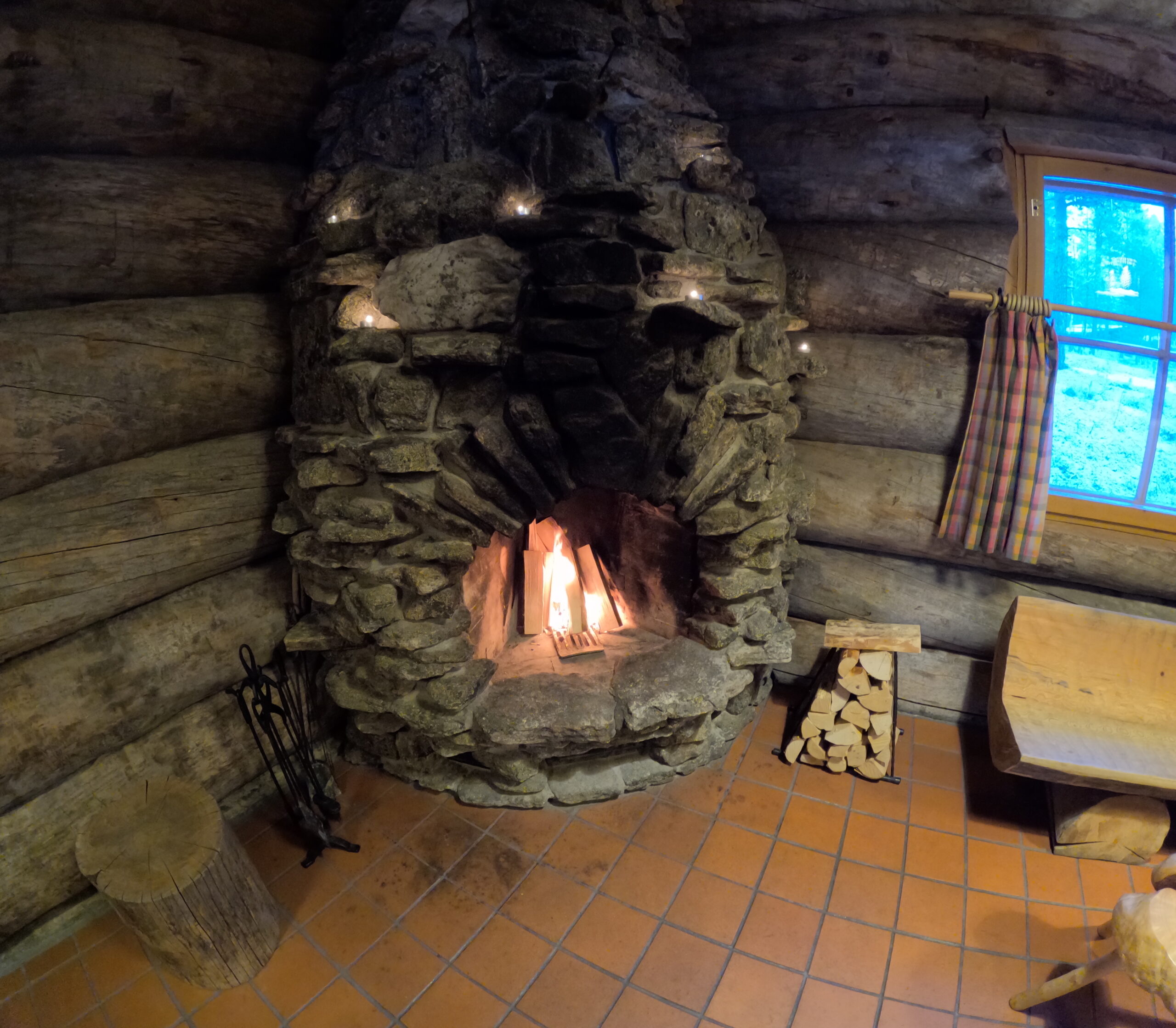 Kakslauttanen Arctic Resort暖炉のある休憩室｜石積み暖炉と丸太造りの温かみある空間｜Saariselkä