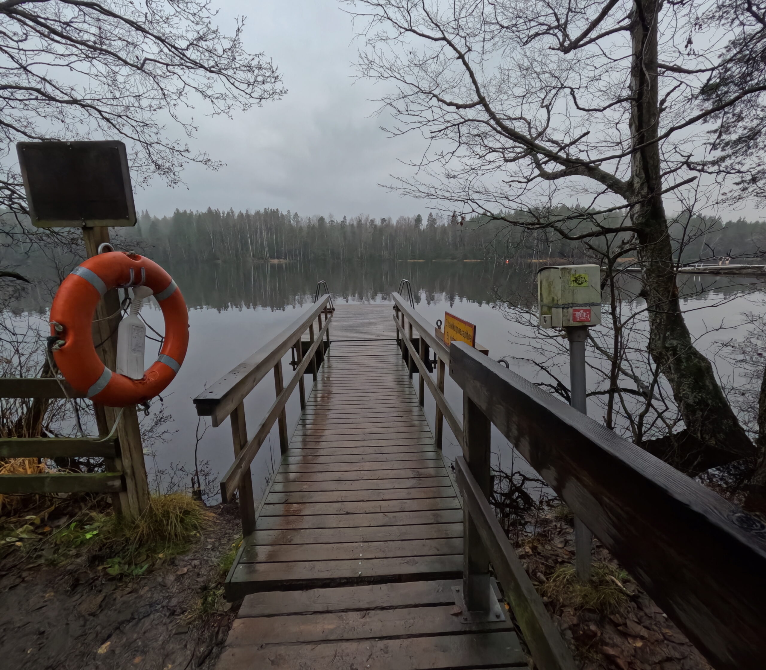 Kuusijärvi湖の水風呂用桟橋｜オレンジ色の救命浮き輪が設置された木製桟橋、森に囲まれた静かな湖｜ヴァンター市・フィンランド