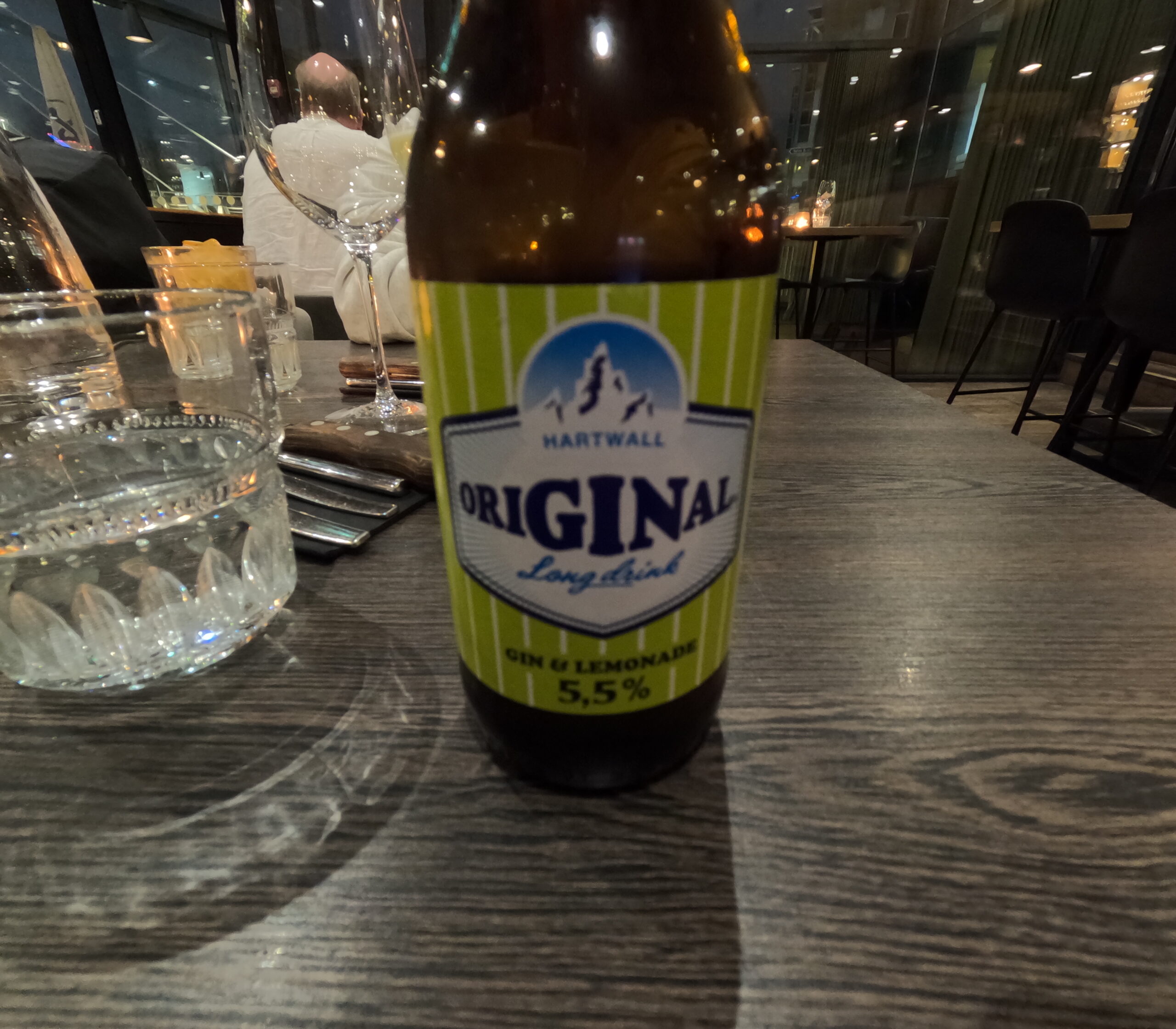 フィンランド名物ロンケロ｜Hartwall Original Long Drink瓶、ジンとレモネード味5.5%、レストランテーブル上、グラスとカトラリー｜Kuumaレストラン・タンペレ