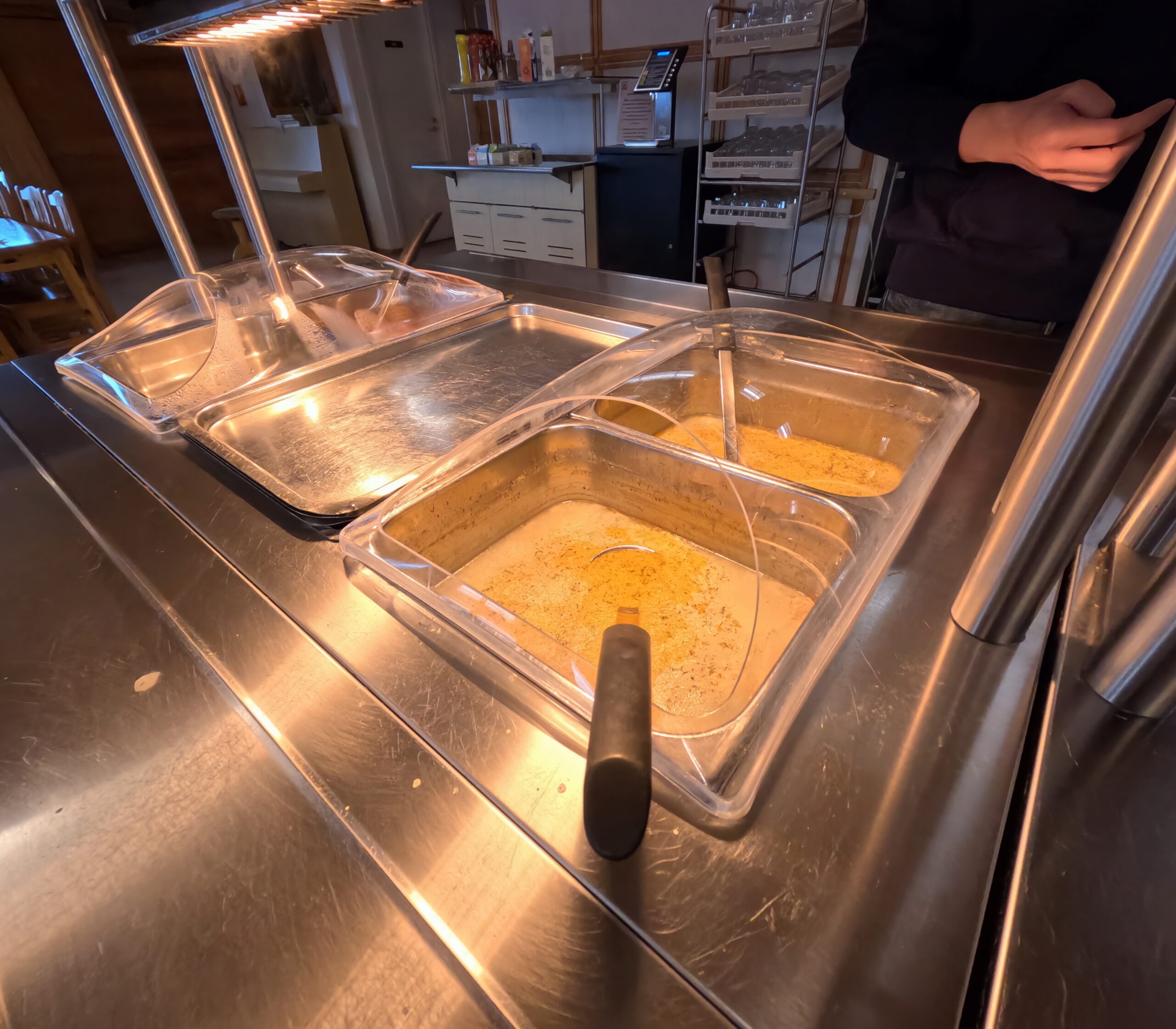 Kiilopääのレストランで提供される温かいビュッフェ料理｜ステンレス製トレーに盛られた湯気立つスープや料理が並ぶ食事シーン｜フィンランド・ラップランド地方