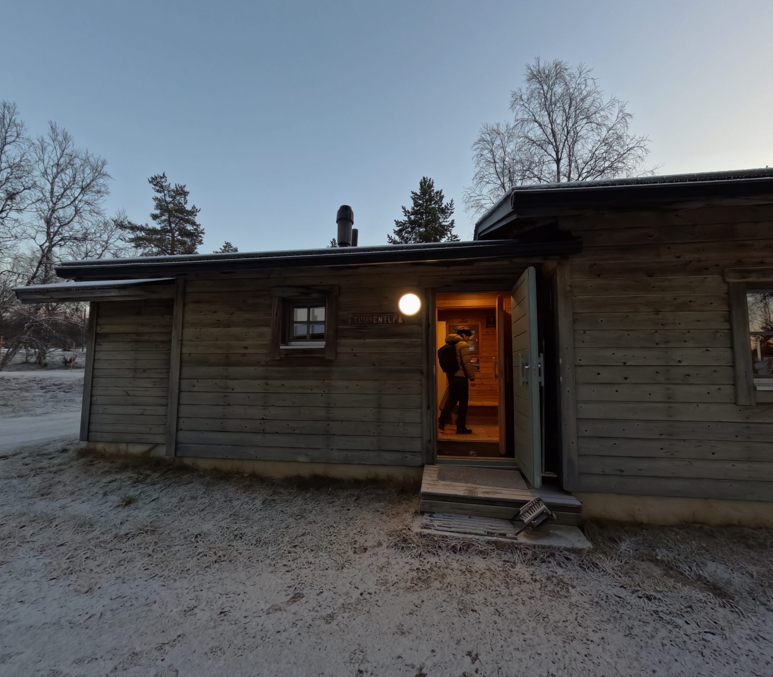 Kiilopääの木製キャビン外観｜雪が薄く積もった冬の夕暮れ時に撮影された北欧らしい静かな佇まい｜フィンランド・ラップランド地方
