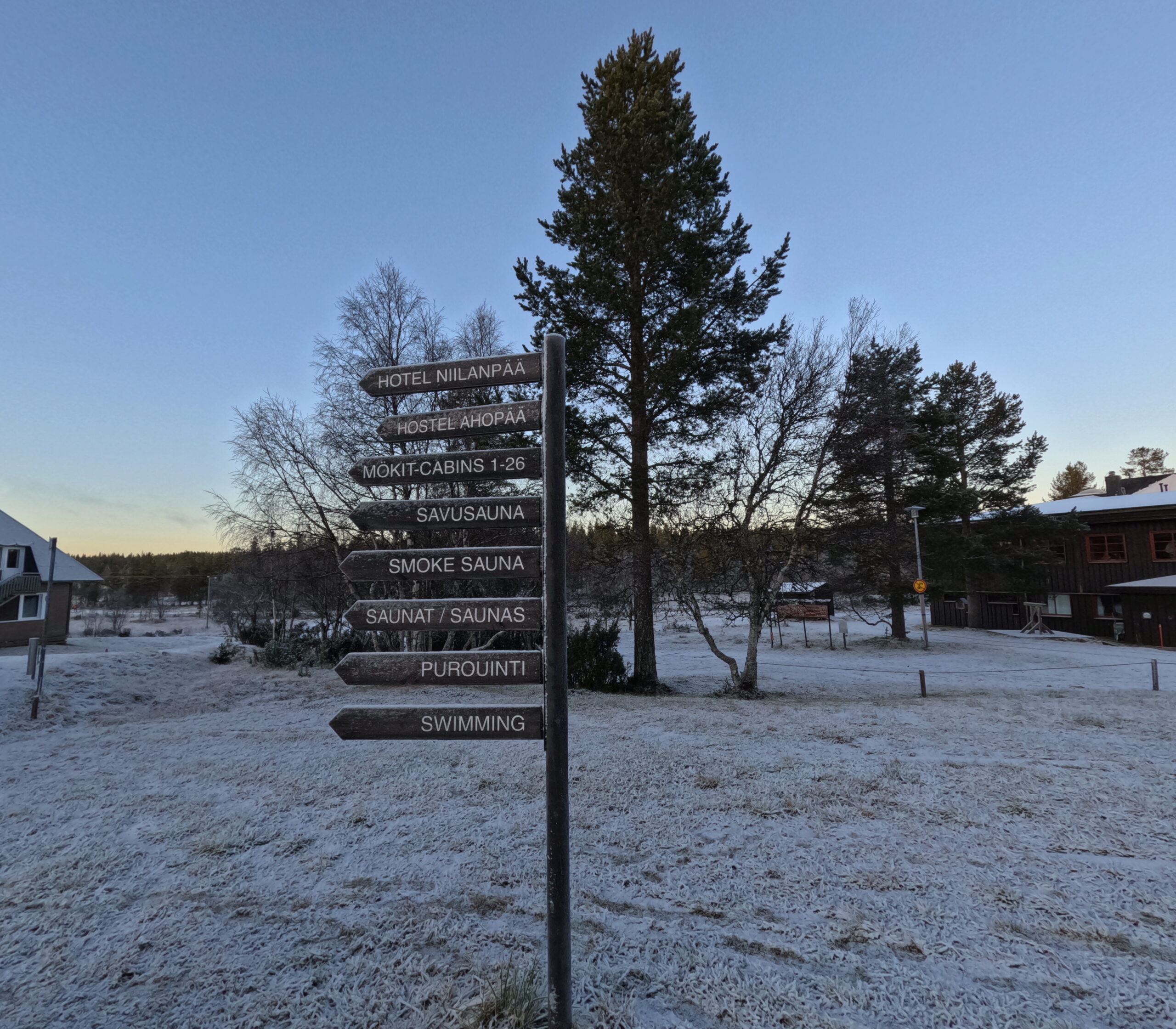 Kiilopää施設案内標識｜「HOTEL NIILANPÄÄ」「MOKITCABINS 1-26」「SAVUSAUNA」「SMOKE SAUNA」「SWIMMING」など複数の方向指示板が並ぶ木製サインポスト｜フィンランド・サーリセルカ