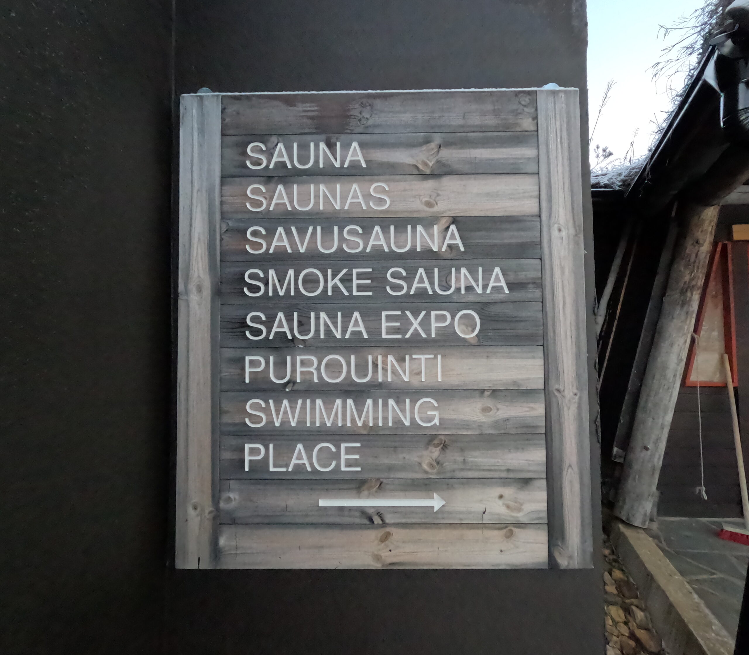 Kiilopää施設案内看板｜木製看板に「SAUNA/SAUNAS/SAVUSAUNA/SMOKE SAUNA/SAUNA EXPO/PUROUINTI/SWIMMING PLACE」の文字と右向き矢印｜フィンランド・サーリセルカ・北極圏
