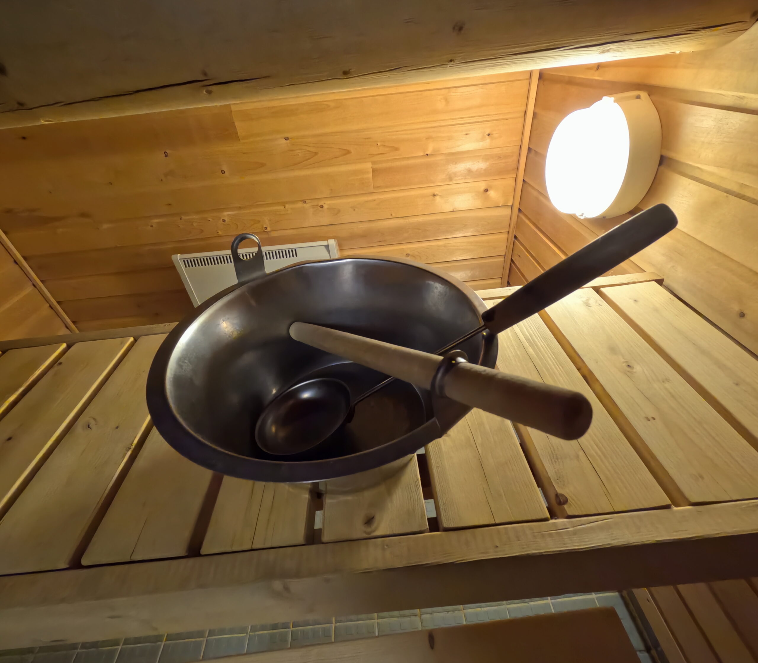 Kiilopääの宿泊施設に設備されたサウナ室内に備え付けられた金属製のボウルと木製の柄杓｜ロウリュに使用する本格的なフィンランドサウナ道具｜フィンランド・ラップランド地方