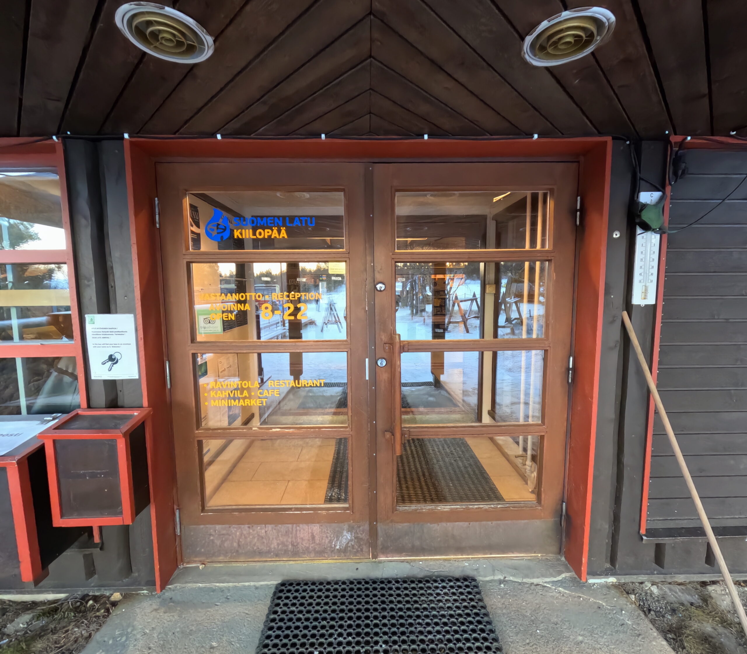 Kiilopää受付入口ドア｜ガラス窓付きの木製ドア、「SUOMEN LATU KIILOPÄÄ」のロゴ、「RECEPTION 8-22」の営業時間表示｜フィンランド・サーリセルカ