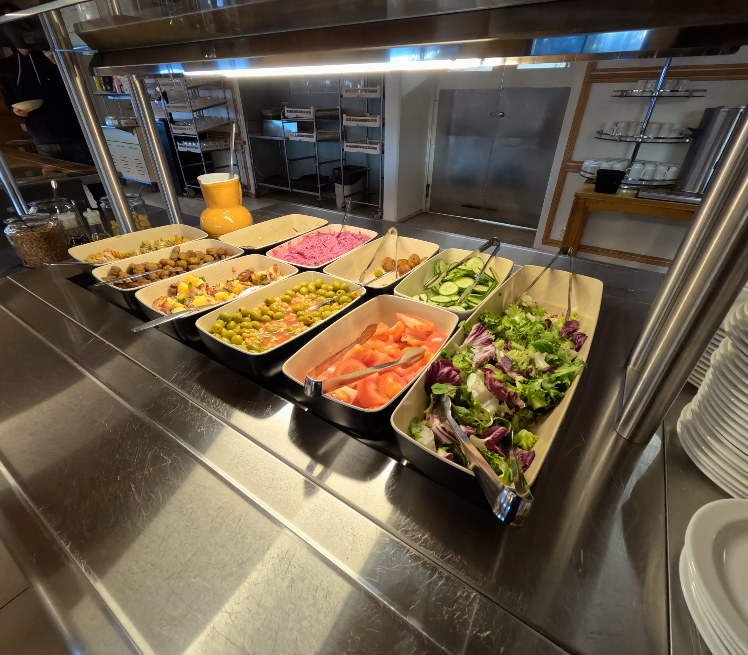 Kiilopääのレストランで提供されるビュッフェスタイルの食事｜新鮮なサラダやミートボールなど多彩な料理が並ぶ明るい照明のディスプレイ｜フィンランド・ラップランド地方
