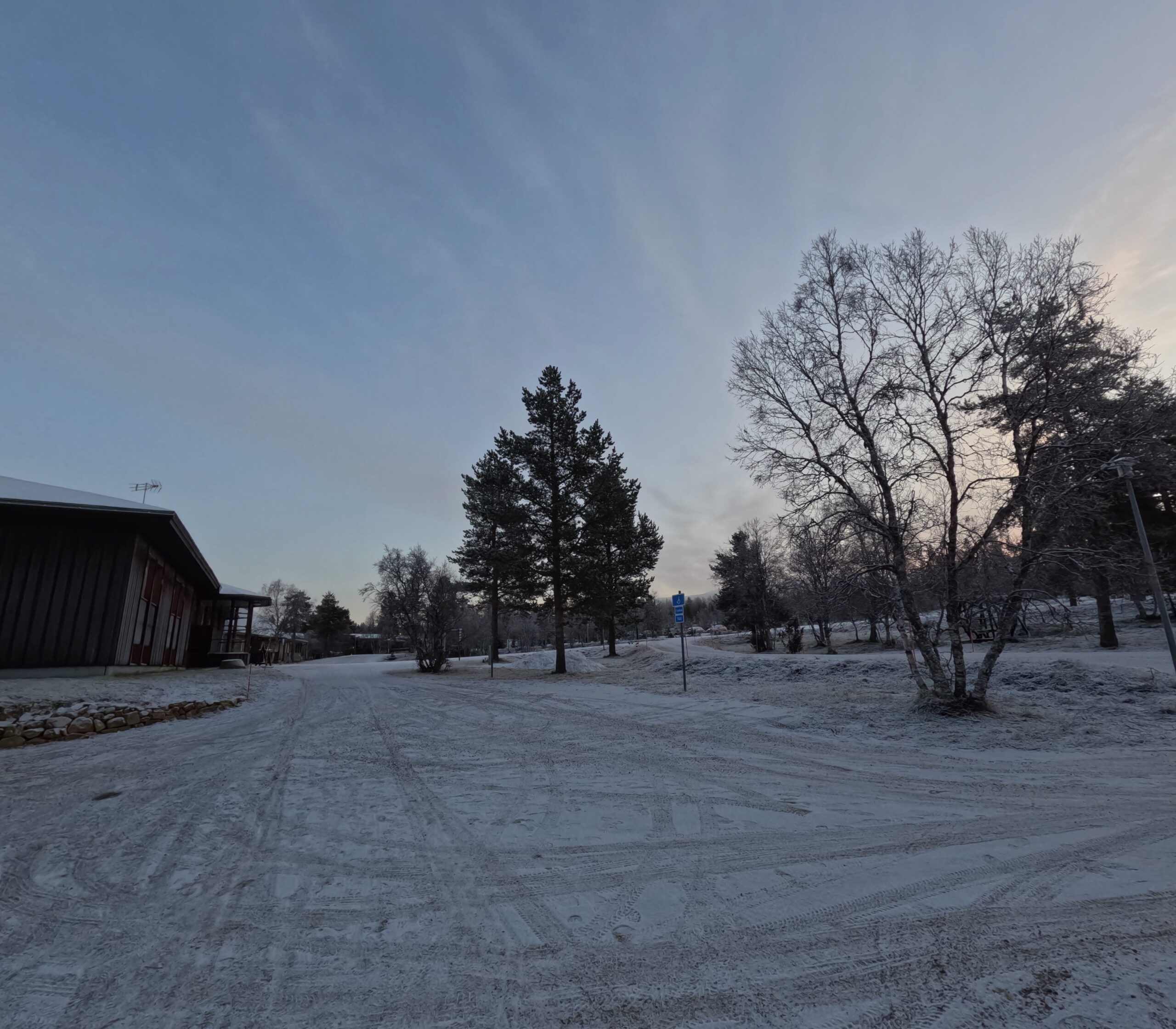 Kiilopää周辺の冬景色｜雪に覆われた小さな丸太小屋、霜の降りた針葉樹の森、白い月が浮かぶ薄明かりの空｜フィンランド・サーリセルカ