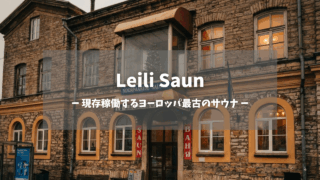 Leili Saun外観サムネイル｜「現存稼働するヨーロッパ最古のサウナ」のテキストオーバーレイ付き、1882年創業のレンガ造り歴史的建築物、オレンジ色の窓明かりが温かみを添える夕景｜タリン・エストニア