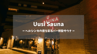 uusi sauna（ウーシサウナ）アイキャッチ画像｜赤いネオンサイン「UUSI SAUNA」と白抜き文字「ヘルシンキの夜を彩るバー併設サウナ」が重なる夜の外観、レンガ造りの建物とガラス張りエントランス｜フィンランド・ヘルシンキ