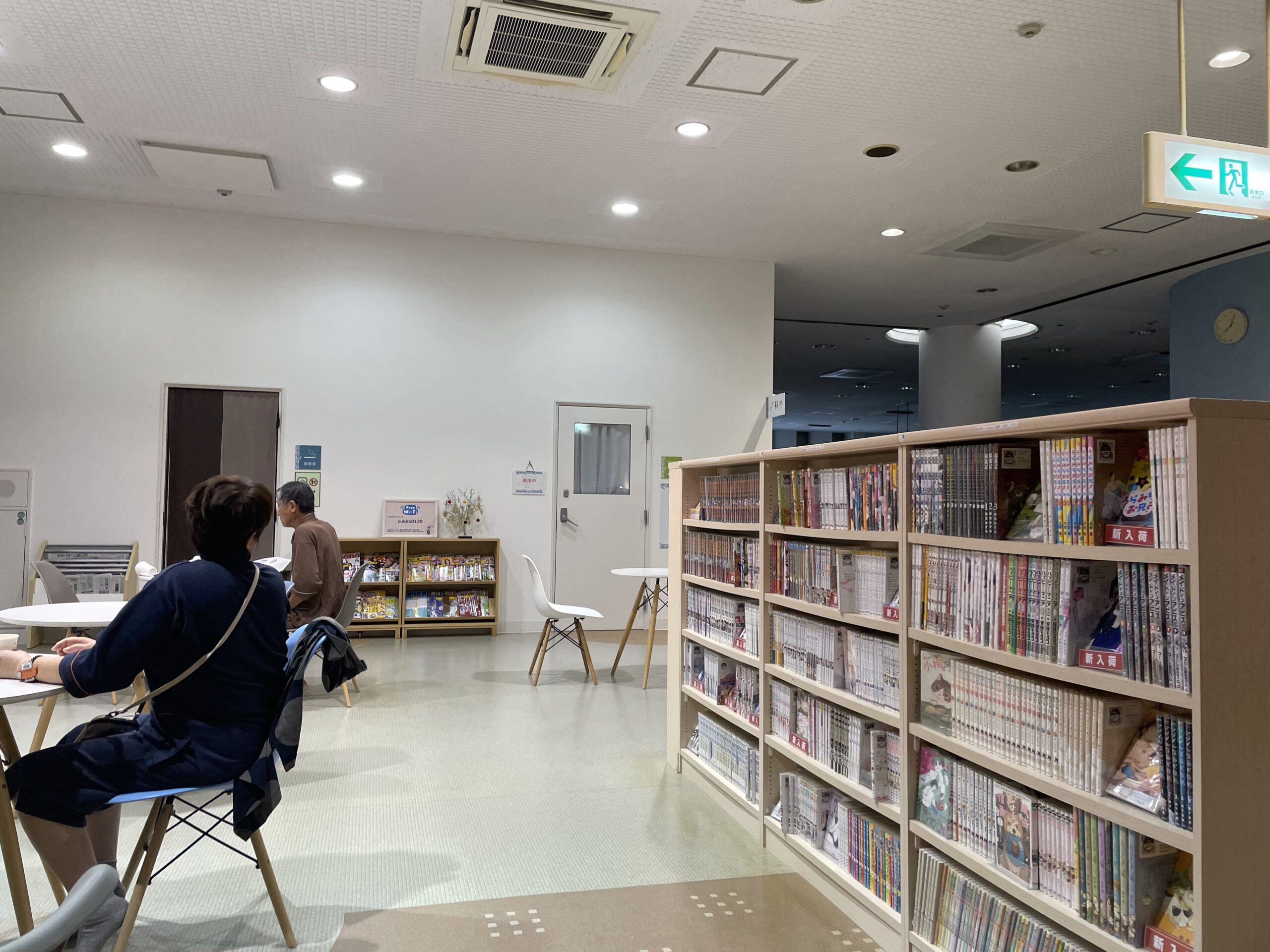 SPA銭湯ゆっこ盛岡の2階ライブラリーラウンジ｜木製の本棚に漫画が並び、テーブル席で読書や休憩を楽しめる空間｜岩手県盛岡市